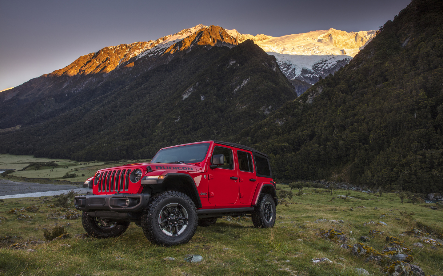 Красный автомобиль Jeep Wrangler на фоне гор