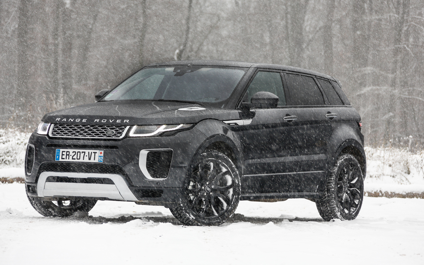 Черный внедорожник Range Rover Evoque Autobiography Si4 на заснеженной дороге