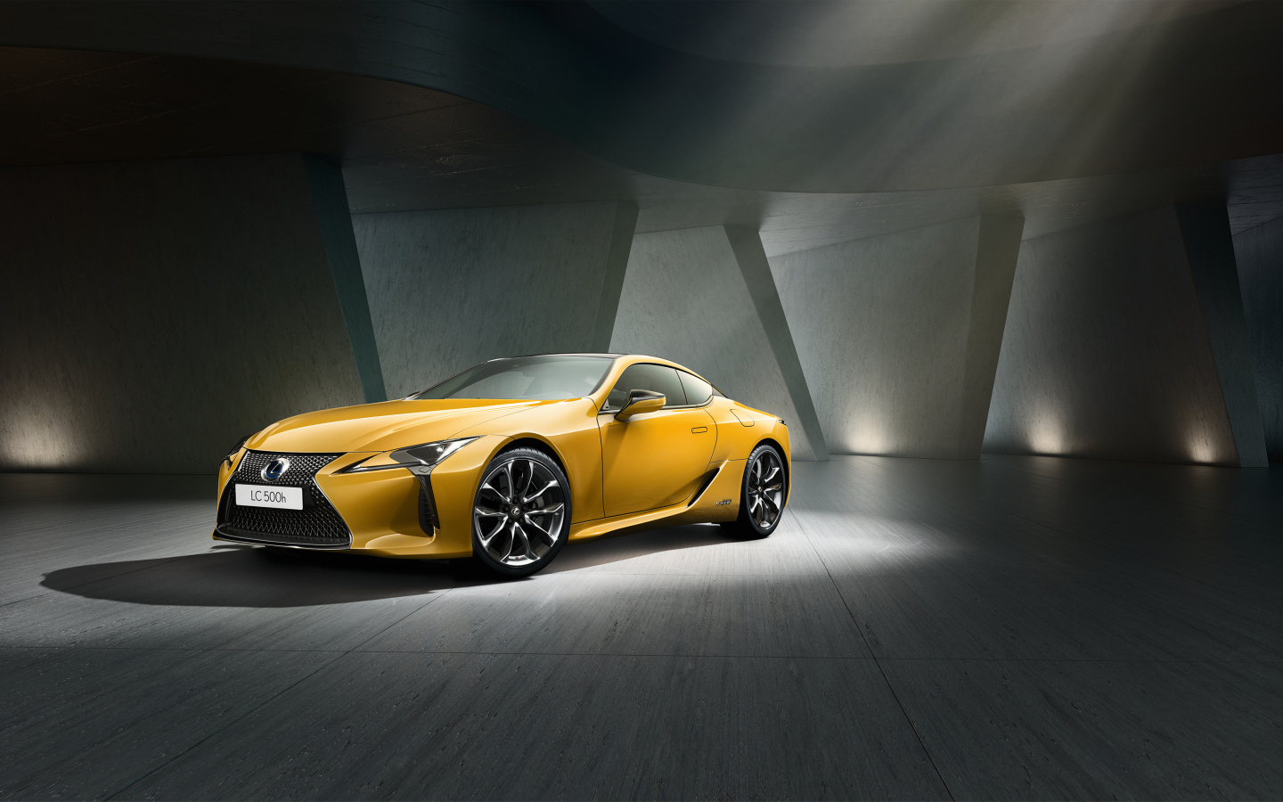 Желтый автомобиль Lexus LC 500 в сером здании