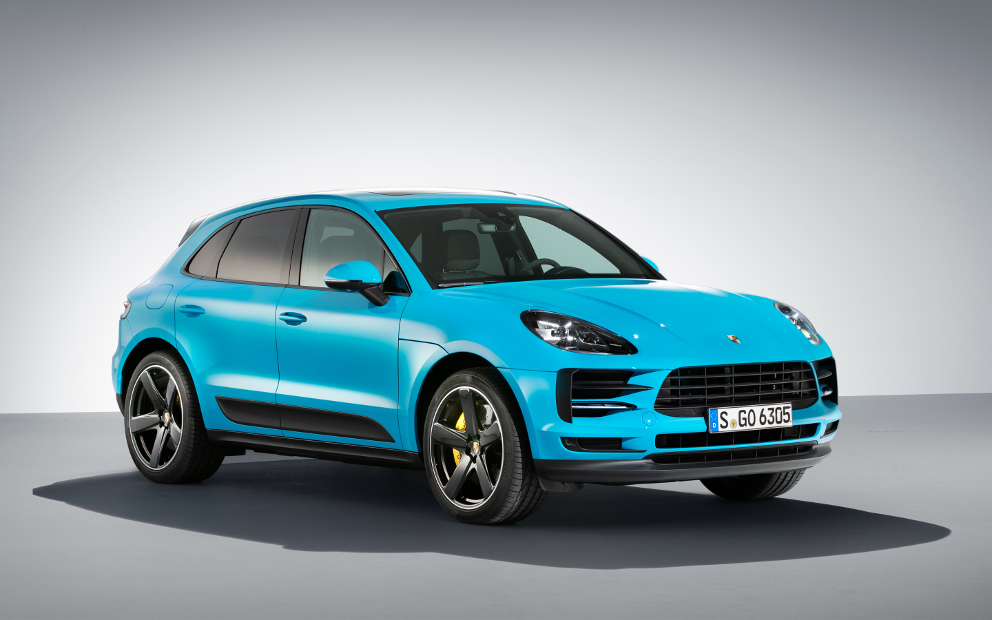 Голубой автомобиль  Porsche Macan S, 2018 на сером фоне