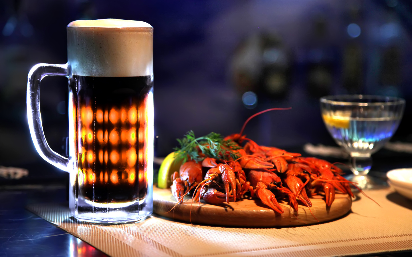 A glass of beer with boiled crawfish on the table