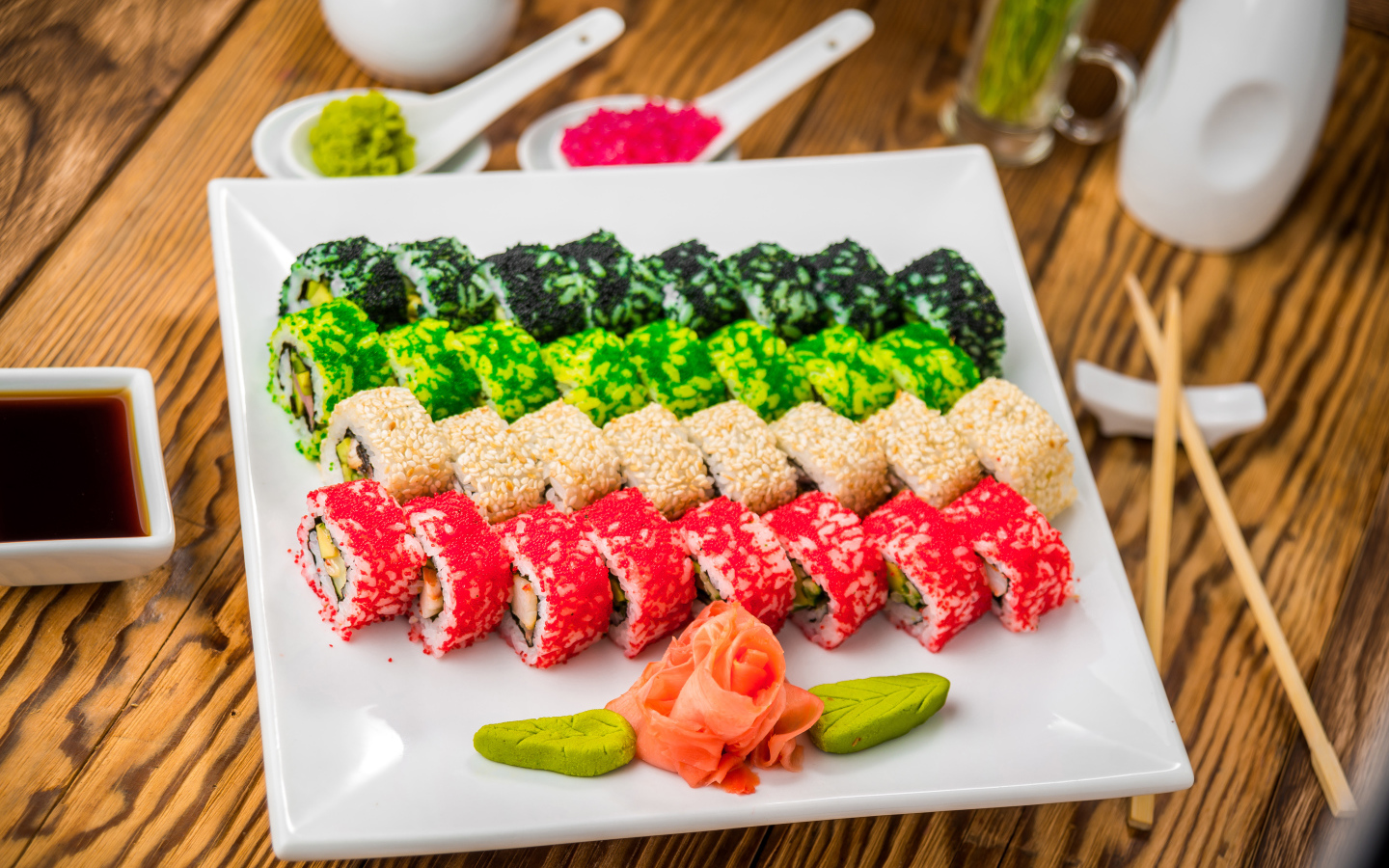 Аппетитные роллы с имбирем и соусом васаби на белой тарелке 