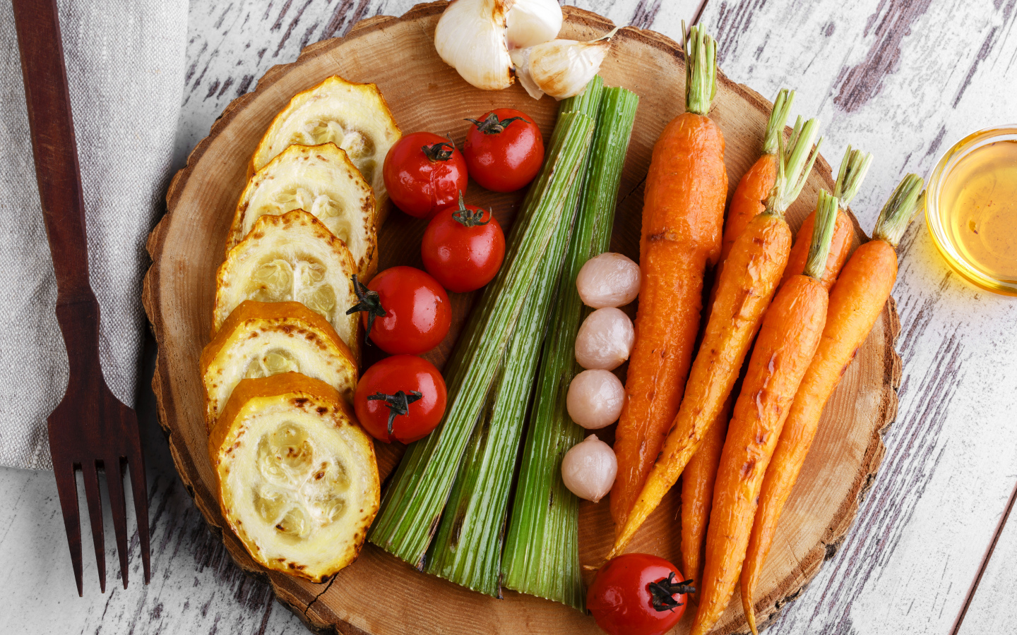 Печеные кабачки, помидоры, морковь, сельдерей и чеснок на разделочной доске
