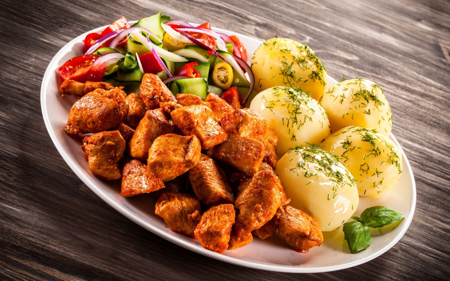 Вареный картофель с мясом и салатом на тарелке