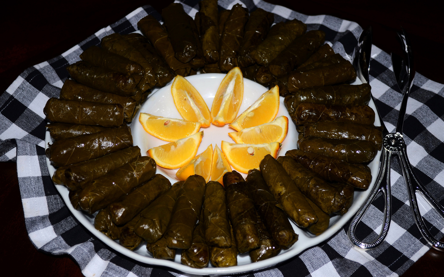 Долма на большом блюде с кусочками апельсина 
