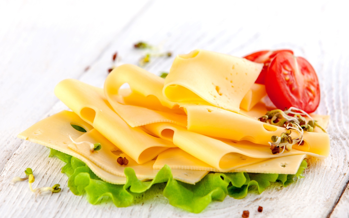 Тонко нарезанный сыр с листом салата и помидором