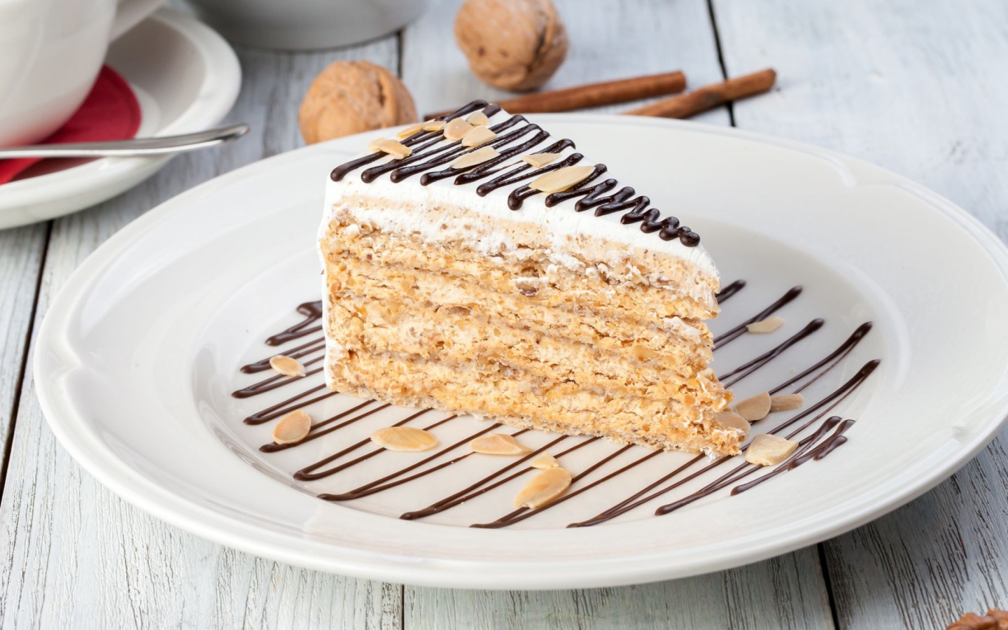 Кусок торта с орехами и шоколадом на белой тарелке