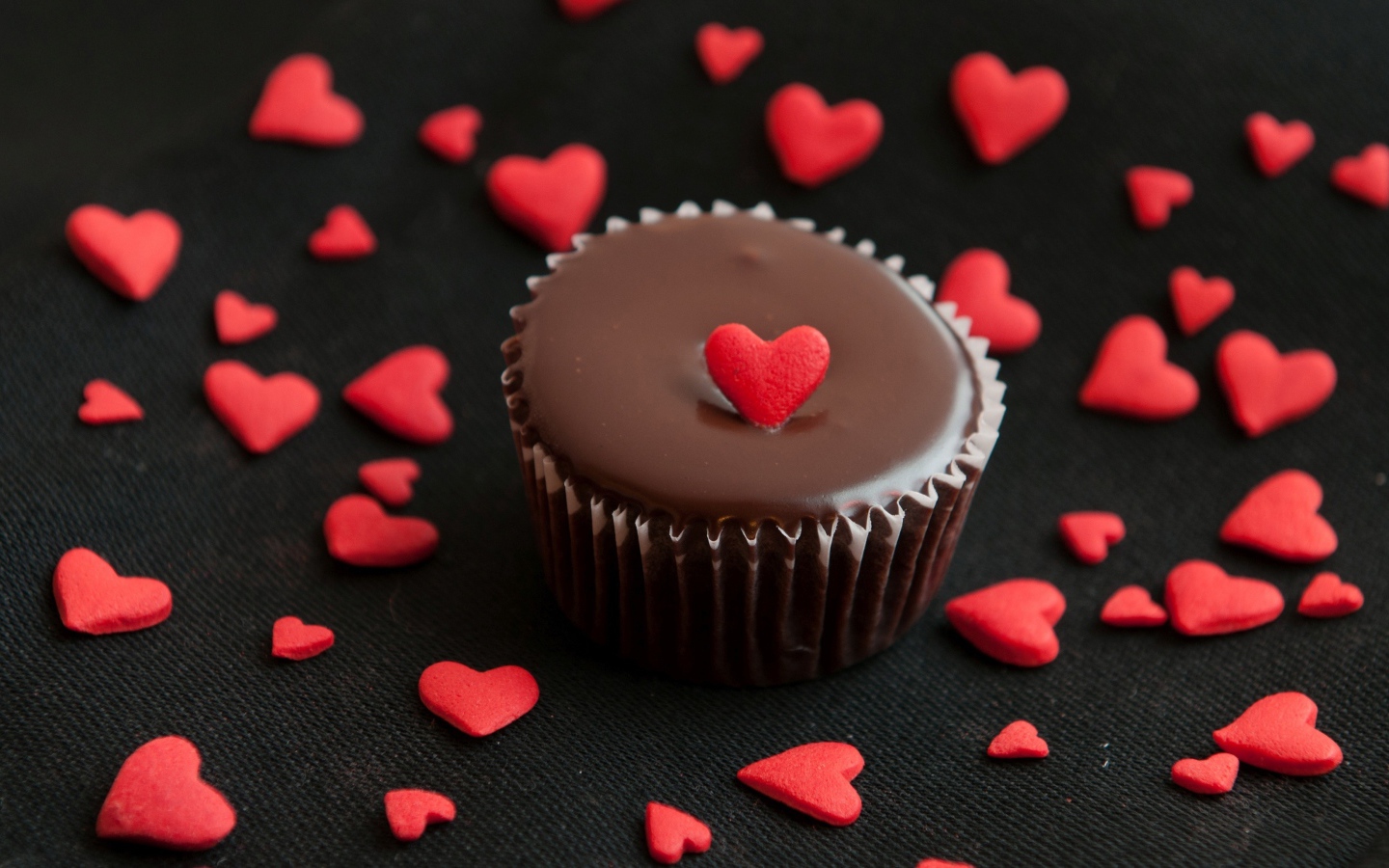 Аппетитный шоколадный кекс украшен маленькими сердечками