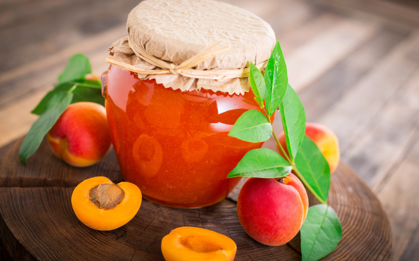 Абрикосовое варенье в банке на столе с абрикосами