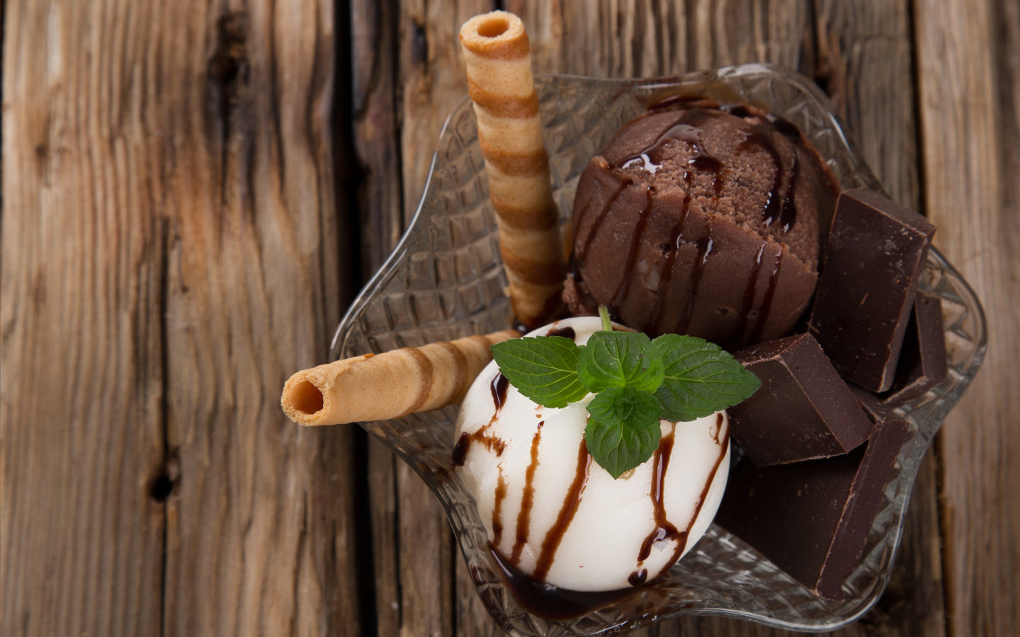 Шарик сливочного и шоколадного мороженого в пиале с трубочками