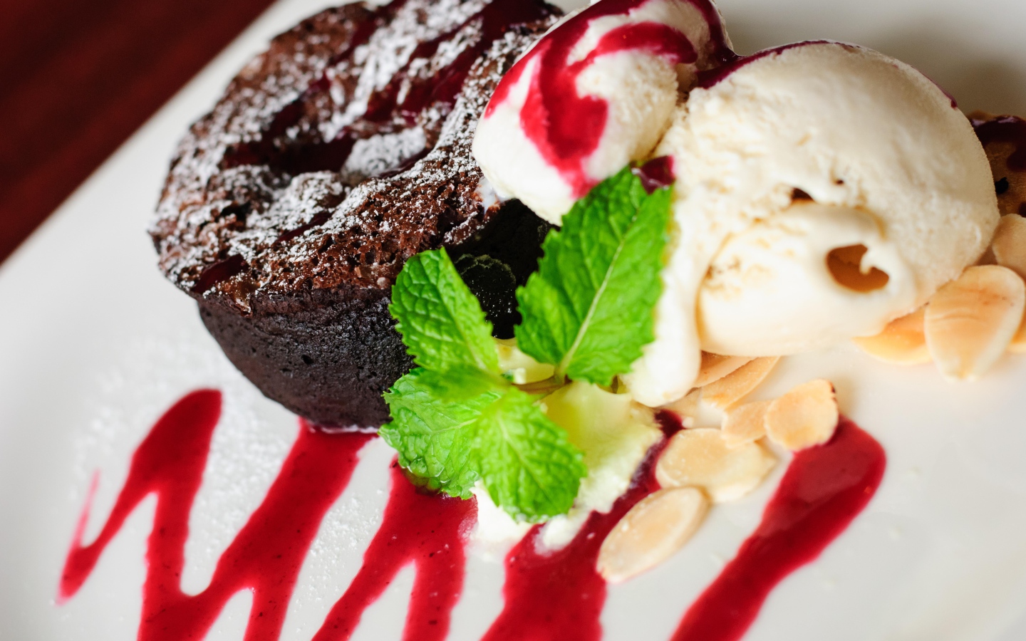 Шоколадное пирожное с мороженым и джемом на тарелке