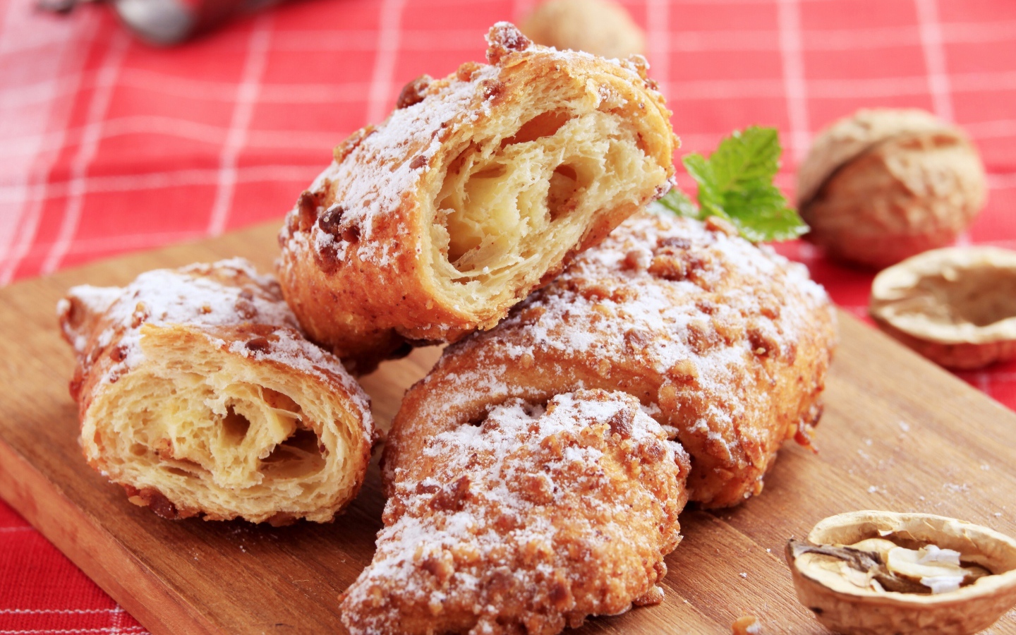 Круассаны с орехом и сахарной пудрой на разделочной доске
