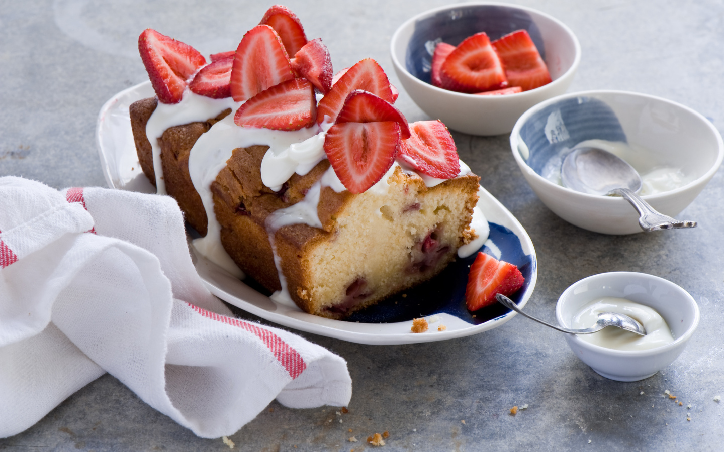 Кекс с кремом на тарелке со свежей клубникой 