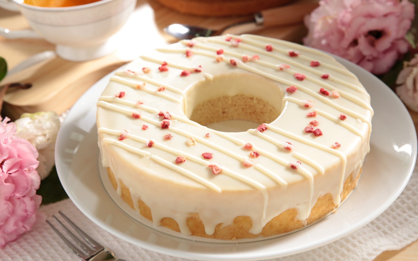 Круглый кекс с глазурью на белом блюде 