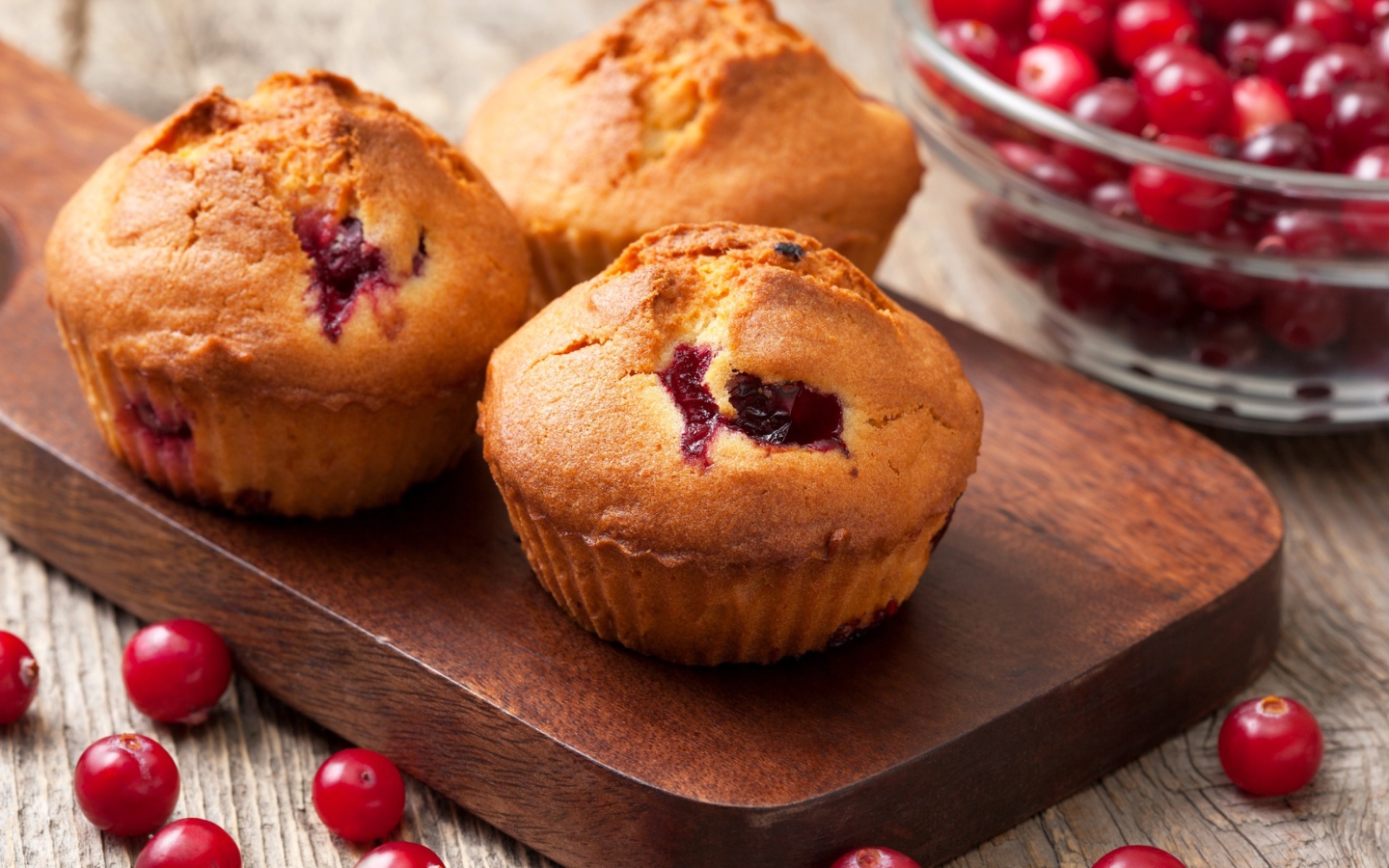 Три кекса с клюквой на разделочной доске