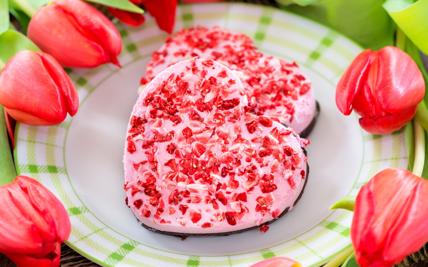 Два печенья в форме сердца на тарелке с тюльпанами 