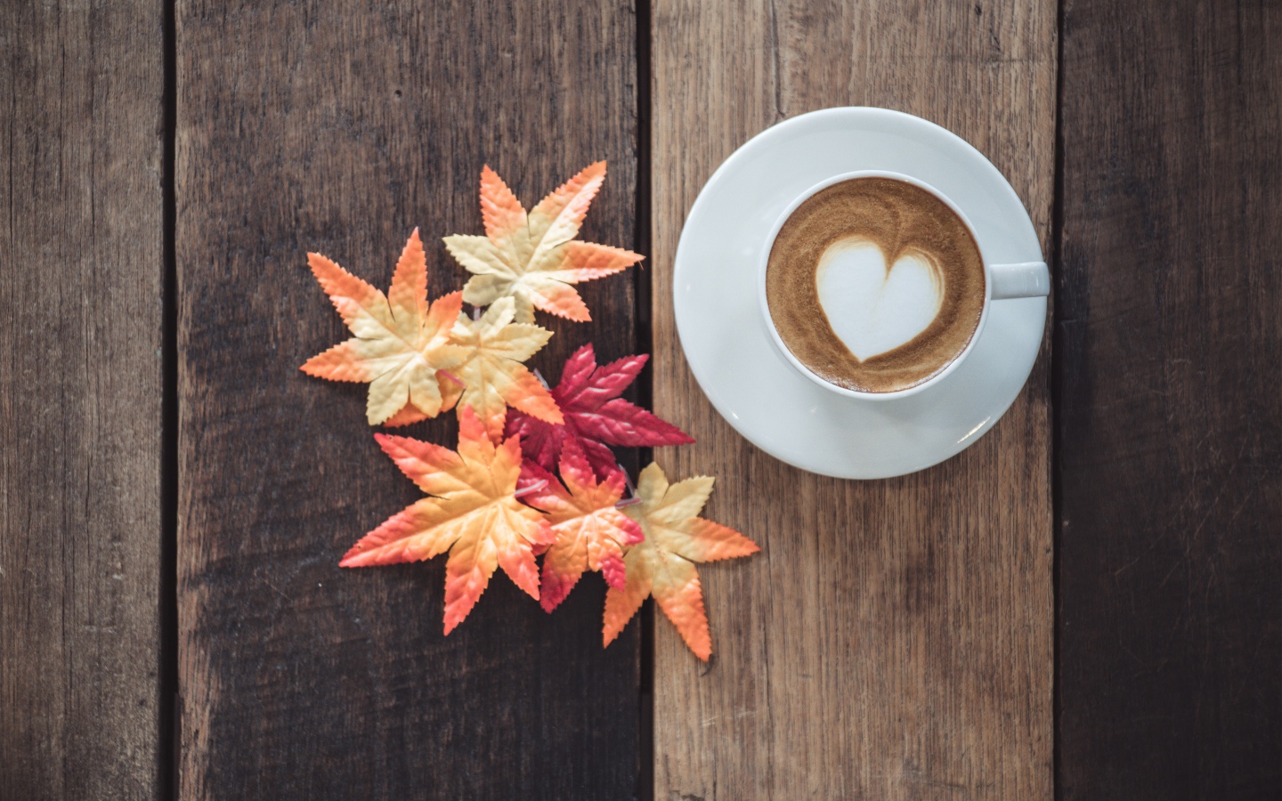 Чашка кофе на деревянном столе с желтыми листьями