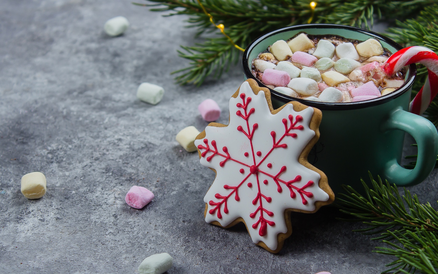 Чашка горячего напитка с кусочками маршмеллоу на столе с печеньем 