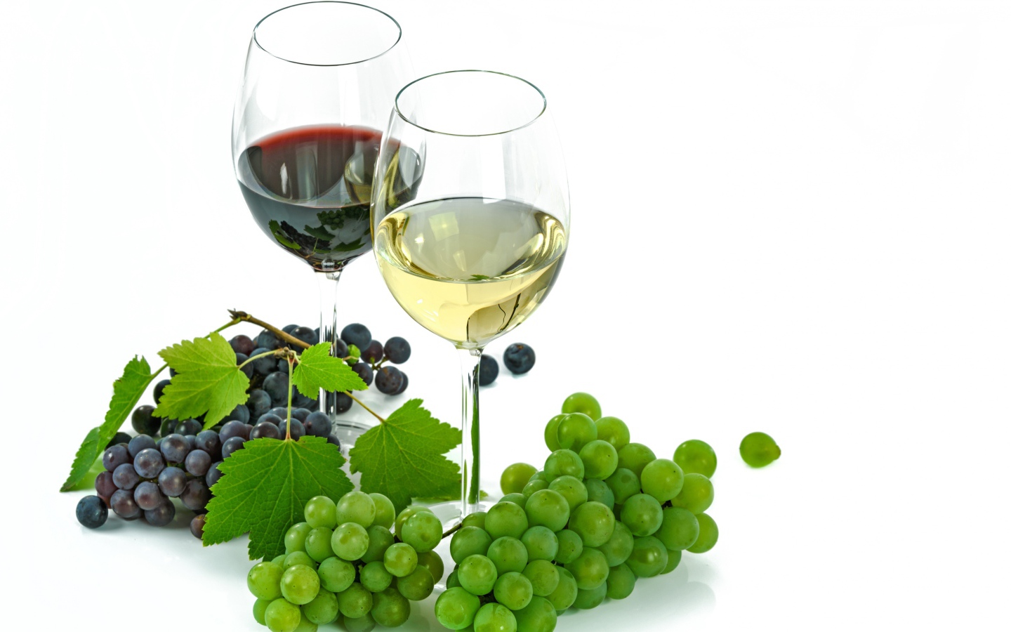 Бокал белого и красного вина на белом фоне с виноградом