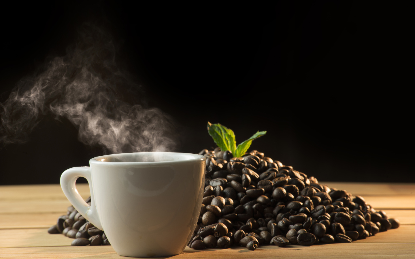 Кофейные зерна на столе с чашкой горячего кофе 