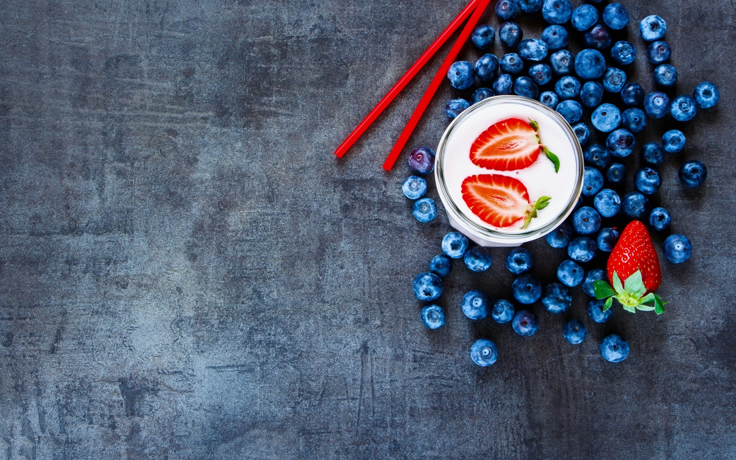 Молочный коктейль с клубникой и черникой на столе 