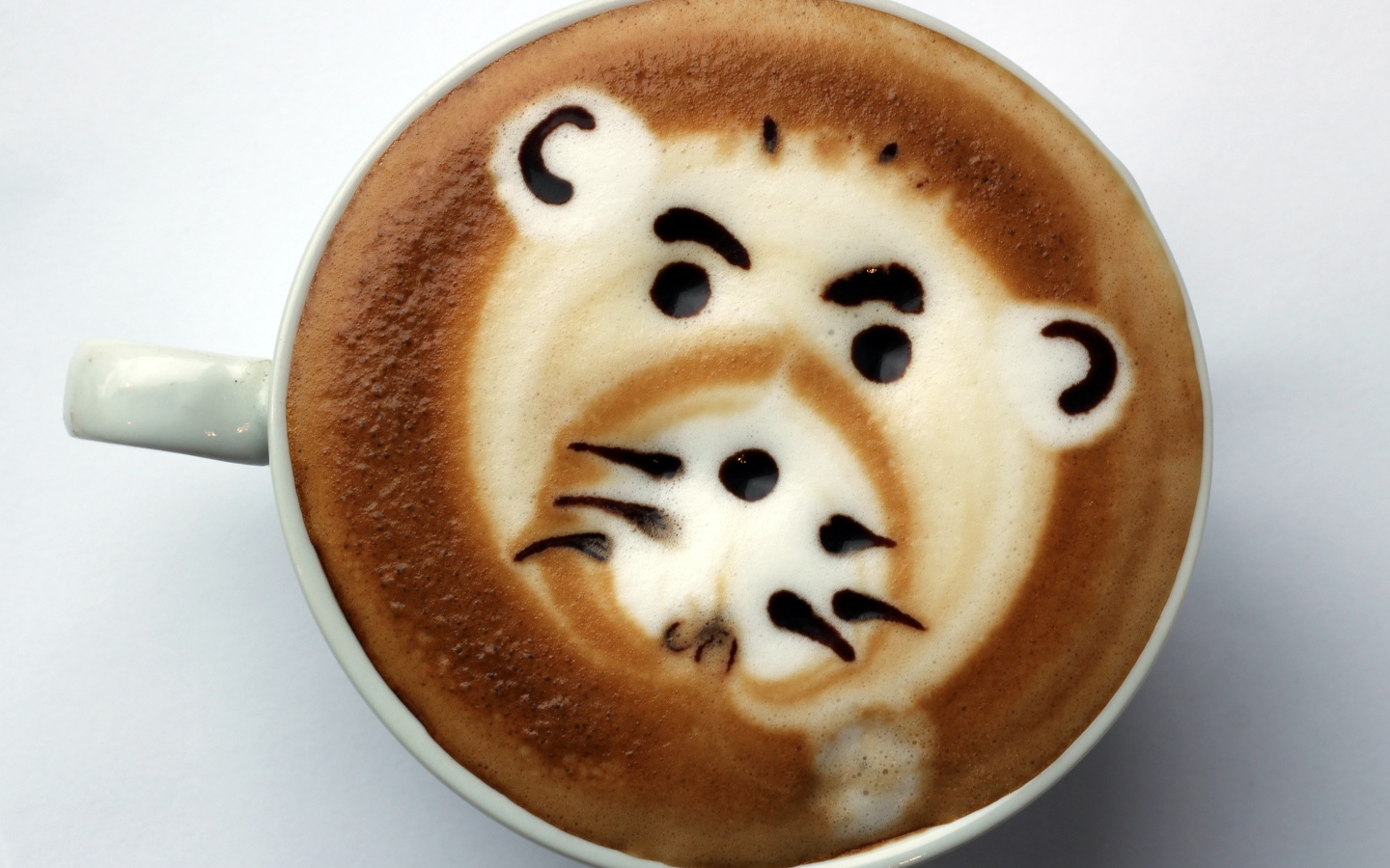 Белая чашка кофе с забавным рисунком на пене