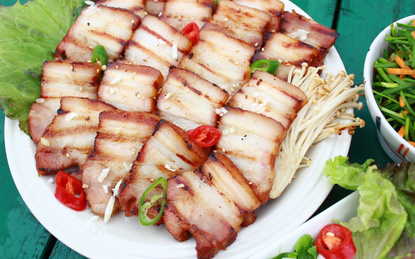 Аппетитное копченое сало на столе с овощами