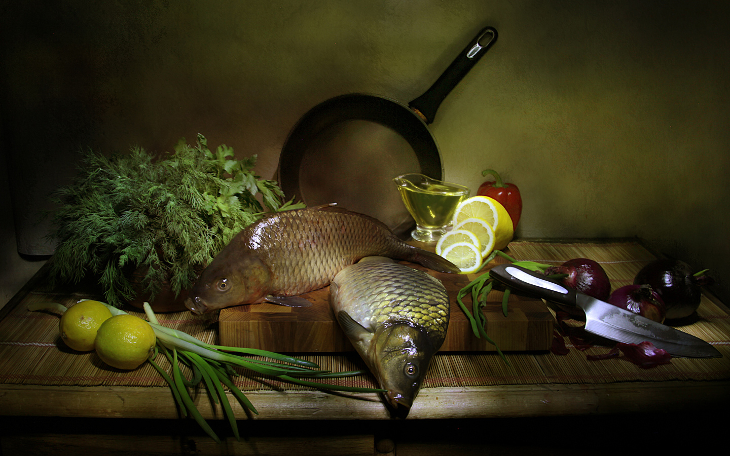Сырая рыба на столе с зеленью, лимонами и луком 