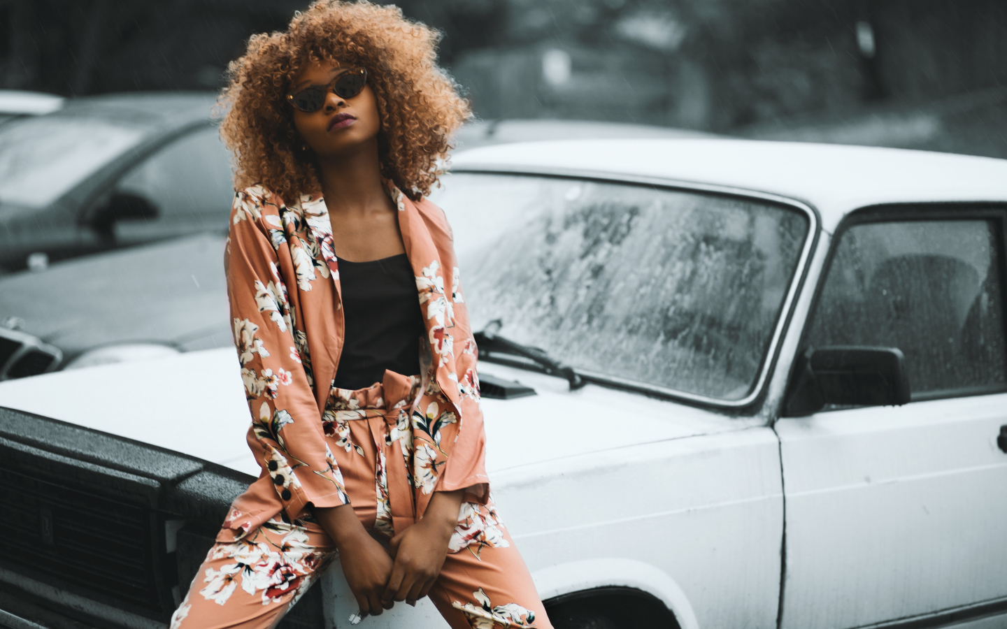 Красивая темнокожая девушка сидит на автомобиле 