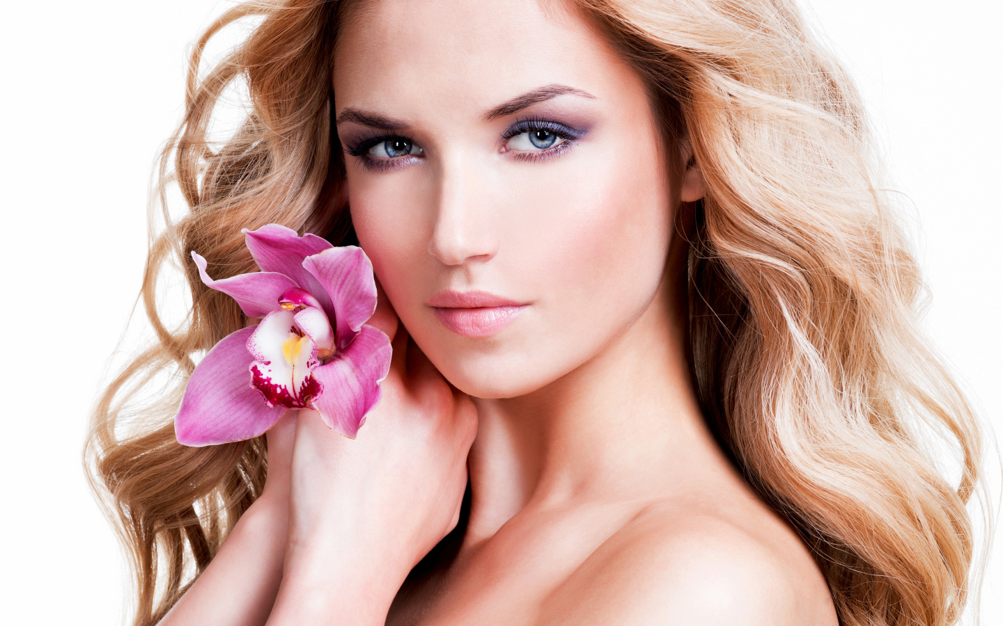 Красивая нежная блондинка с цветком орхидеи на белом фоне