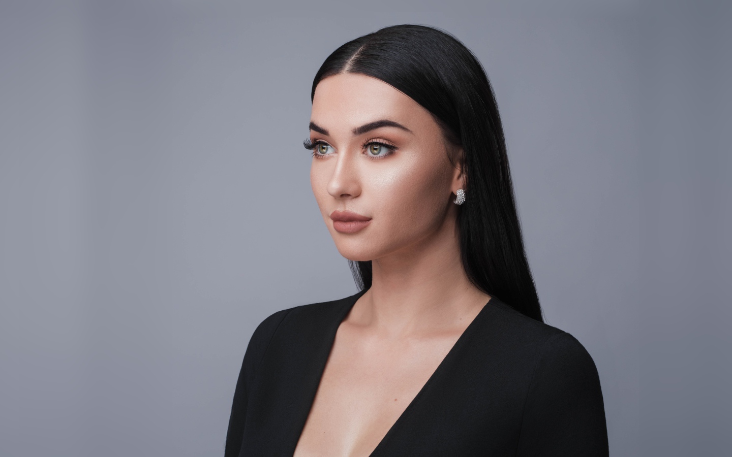 Красивая длинноволосая брюнетка в черном фото на сером фоне