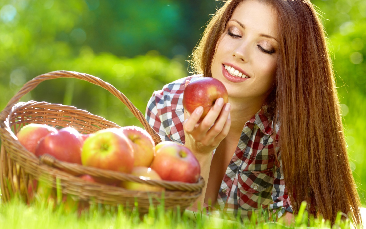 Красивая улыбающаяся девушка с корзиной красных яблок