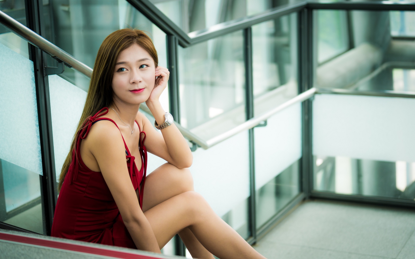 Красивая молодая девушка азиатка сидит на ступенях