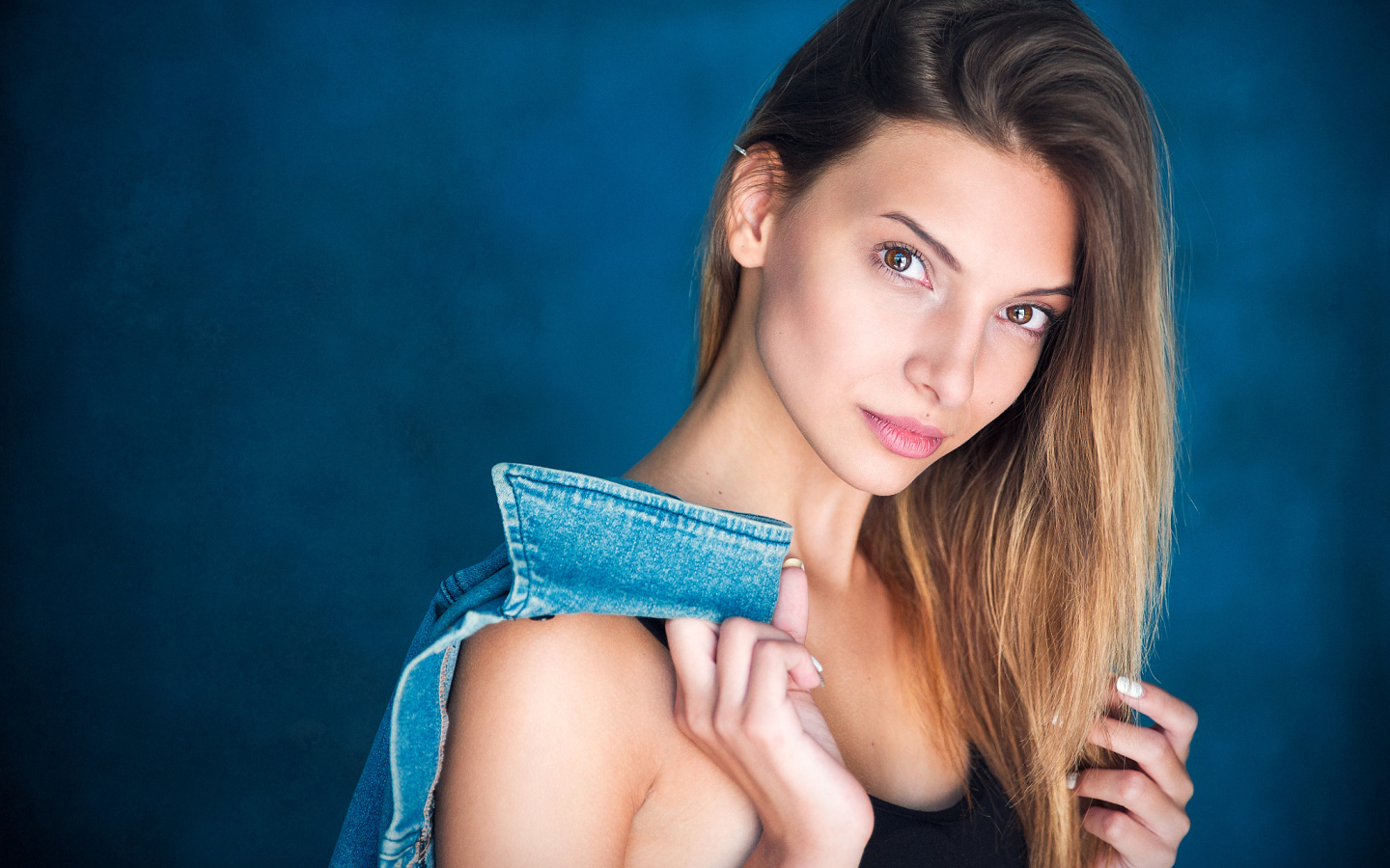 Кареглазая шатенка с джинсовой курткой в руке