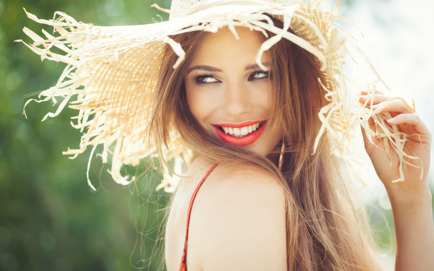 Улыбающаяся девушка в соломенной шляпе летом