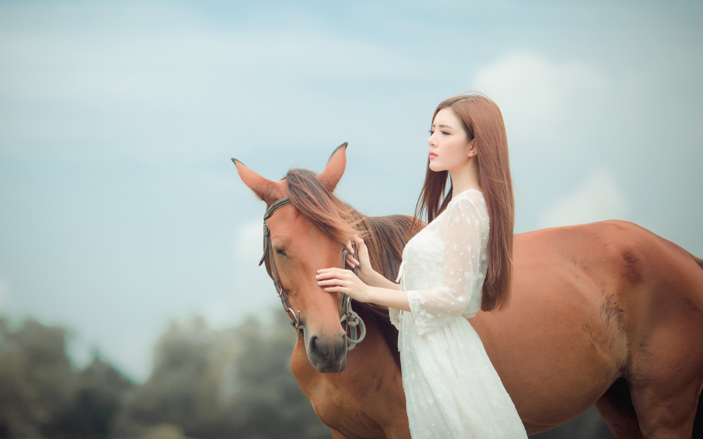 Молодая азиатка в белом платье с лошадью 