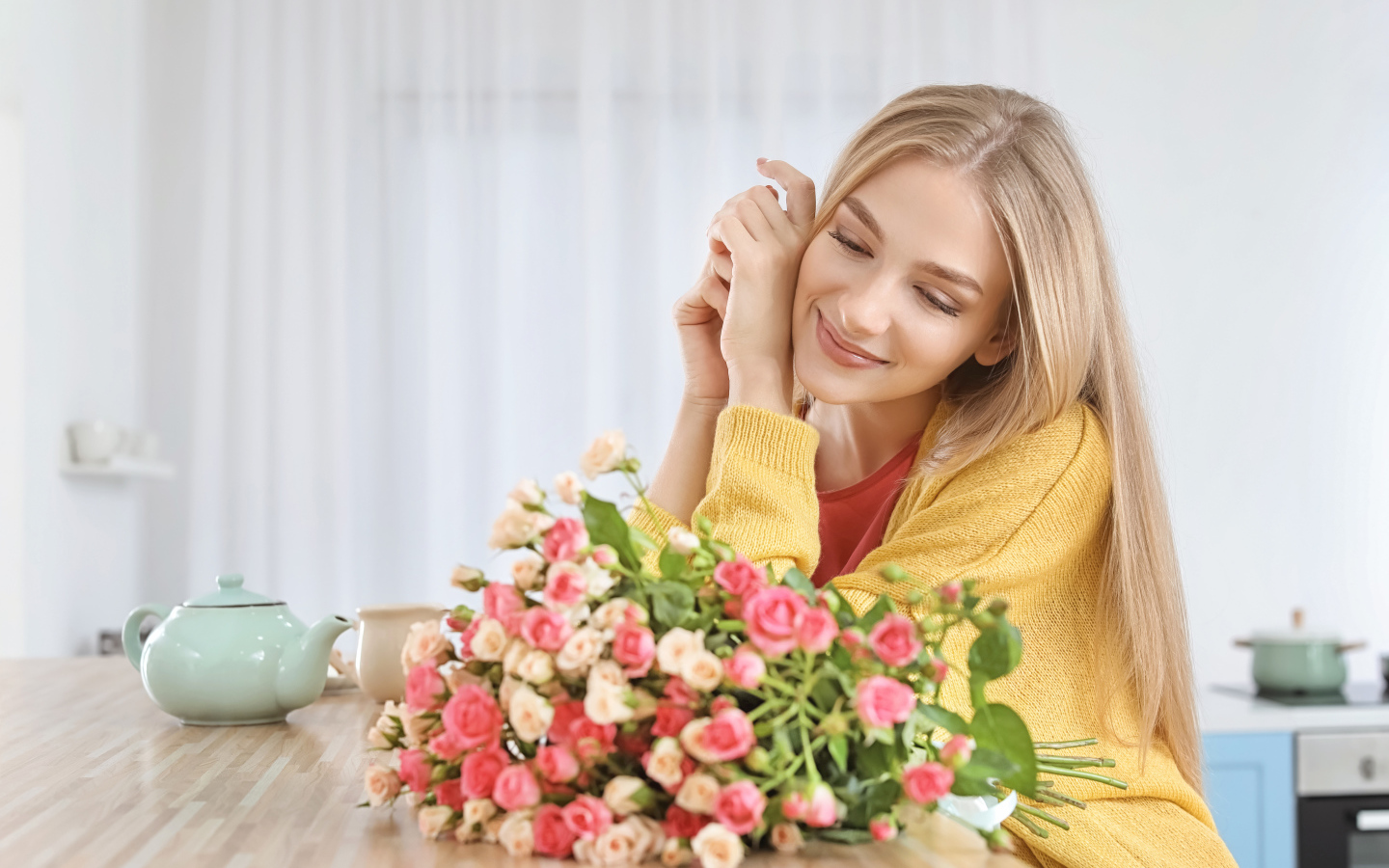 Молодая блондинка с букетом роз на столе