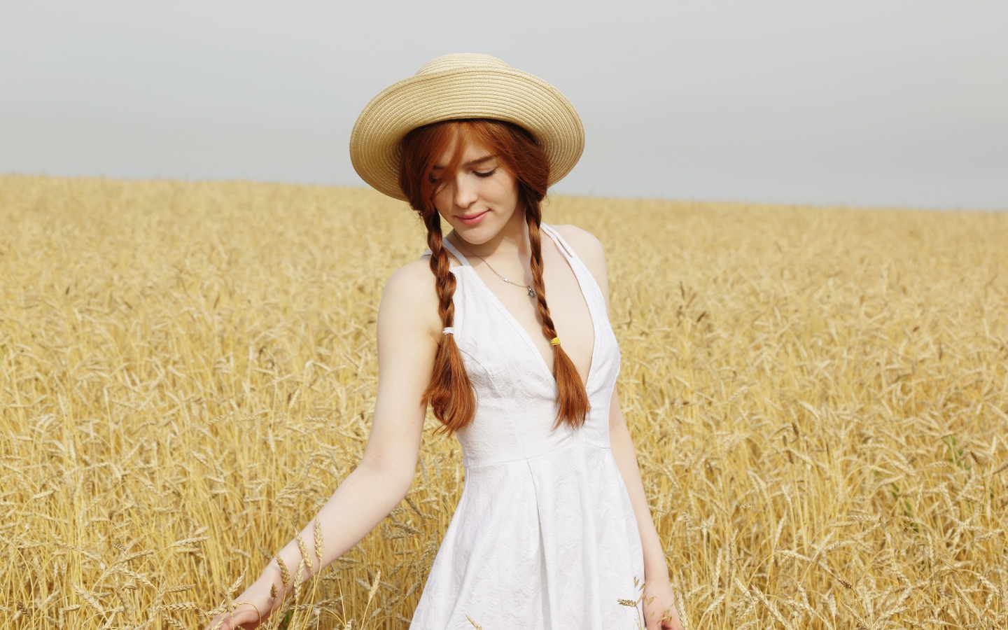 Молодая девушка в белом платье на поле с пшеницей