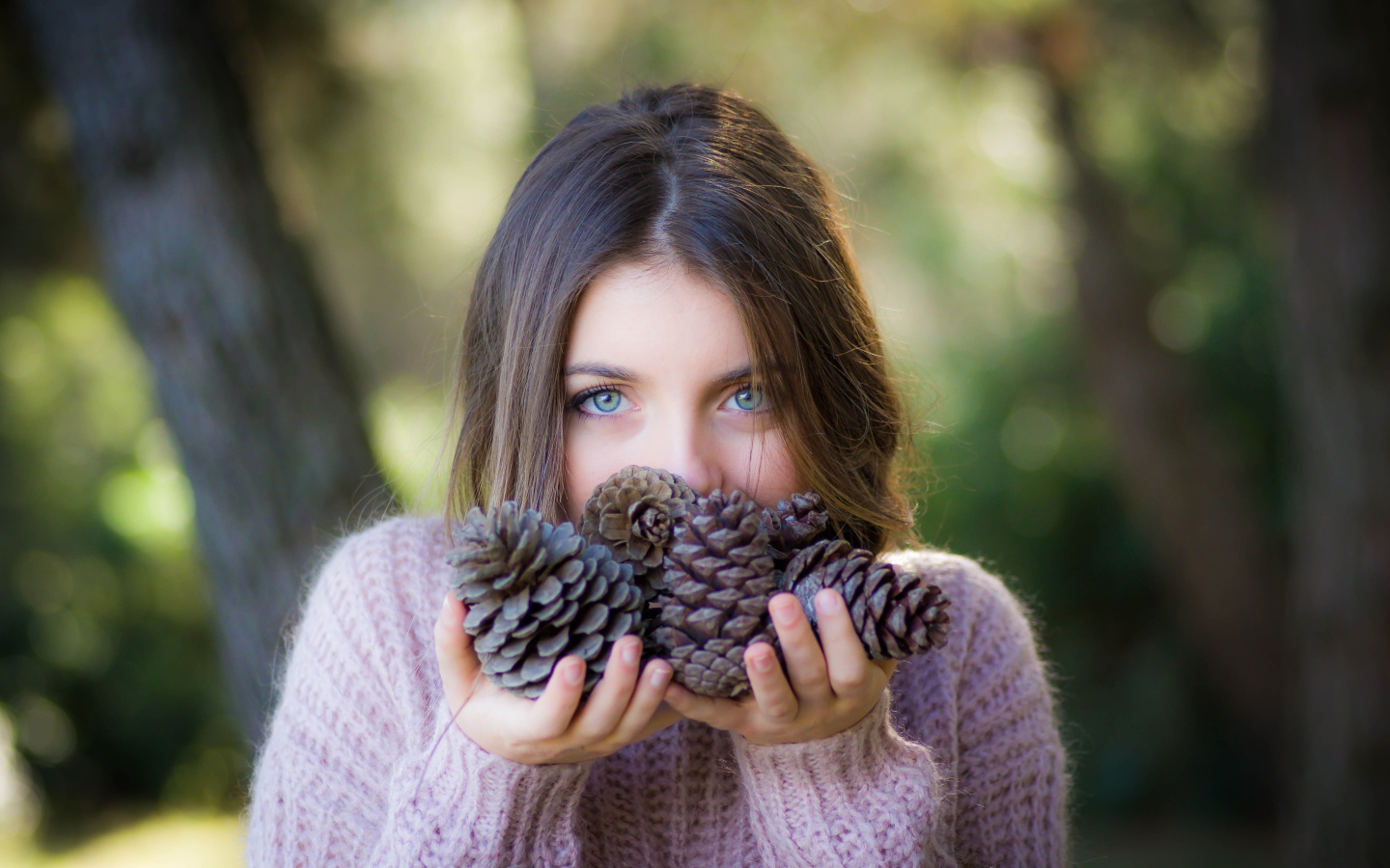 Молодая девушка с шишками в руках