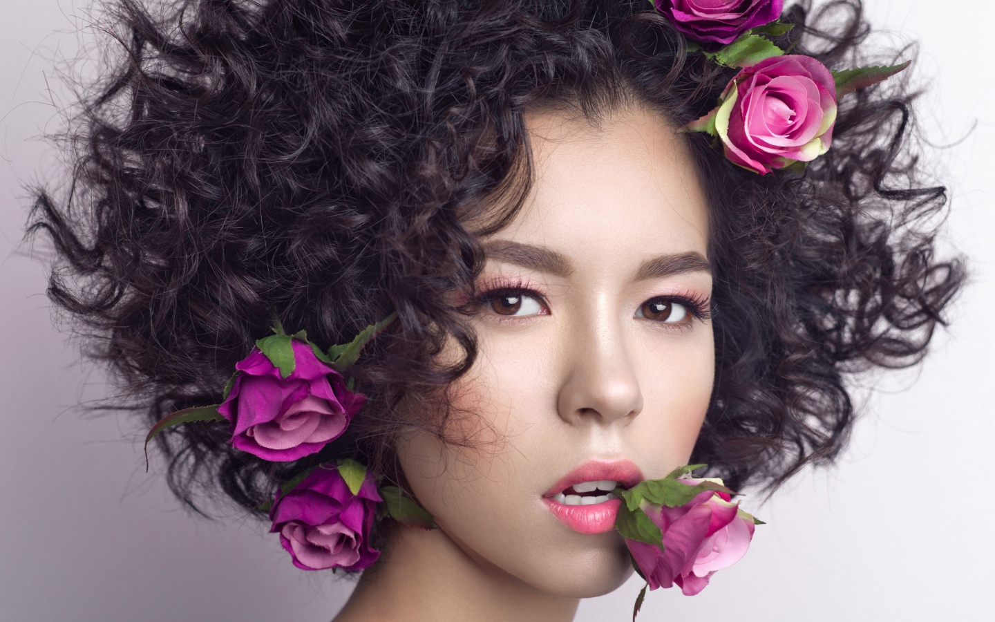 Молодая девушка с кудрявыми волосами с розами