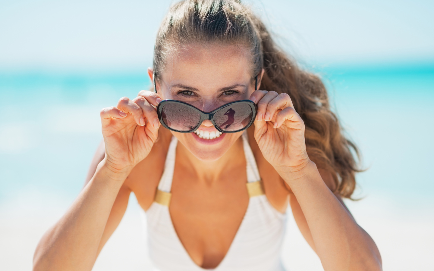 Молодая улыбающаяся девушка в солнечных очках 