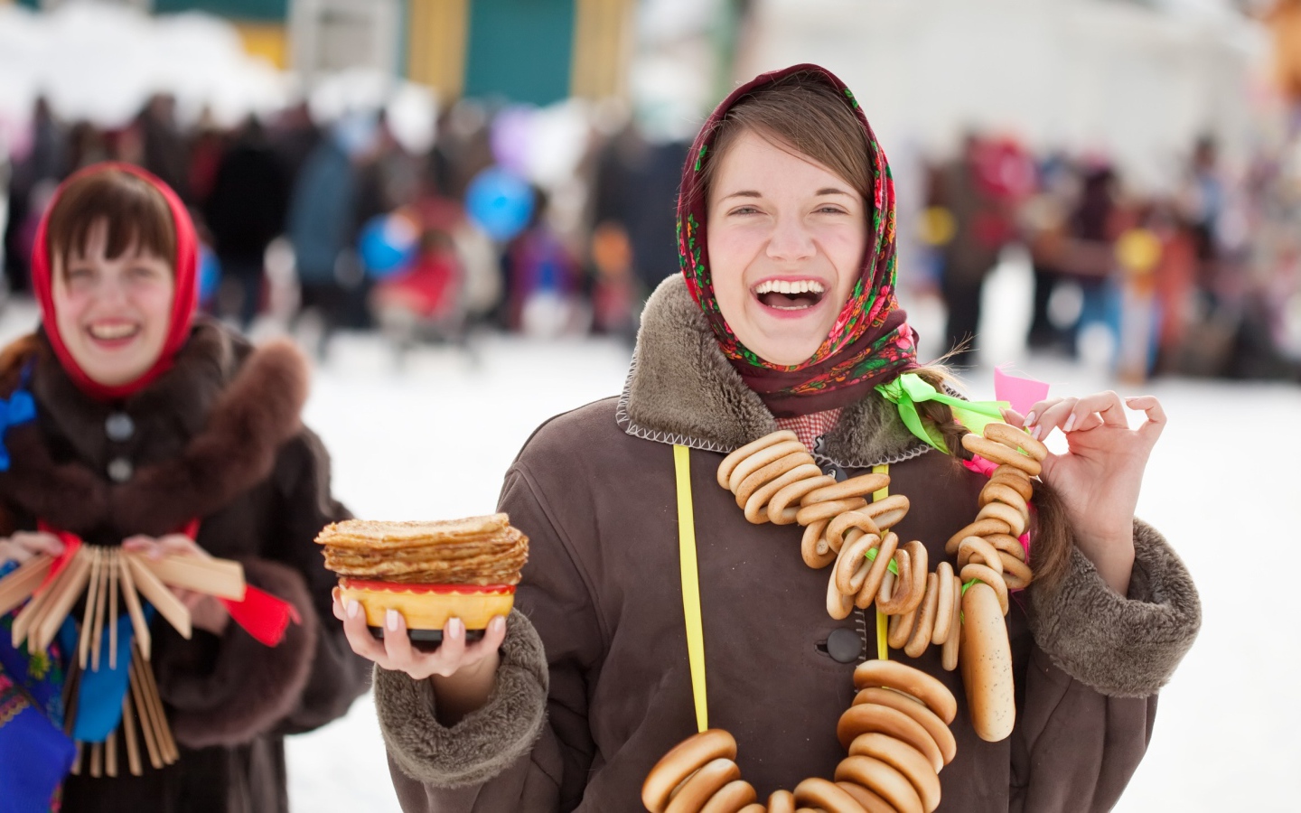 Улыбающаяся девушка с угощениями на праздник Масленица 2018