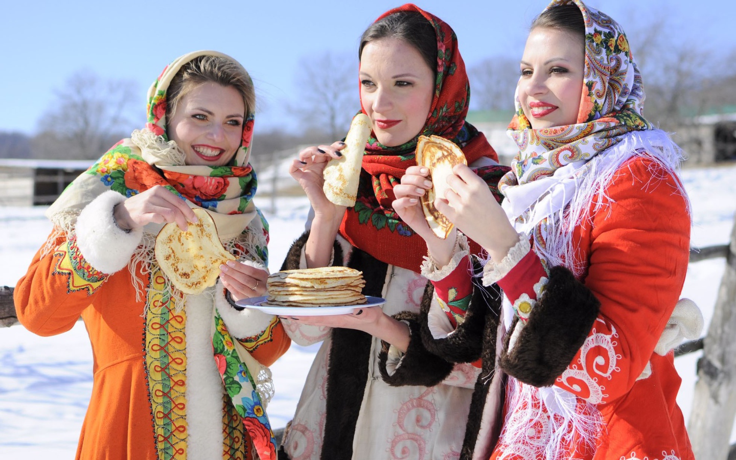 Три молодые красивые девушки с блинами на Масленицу