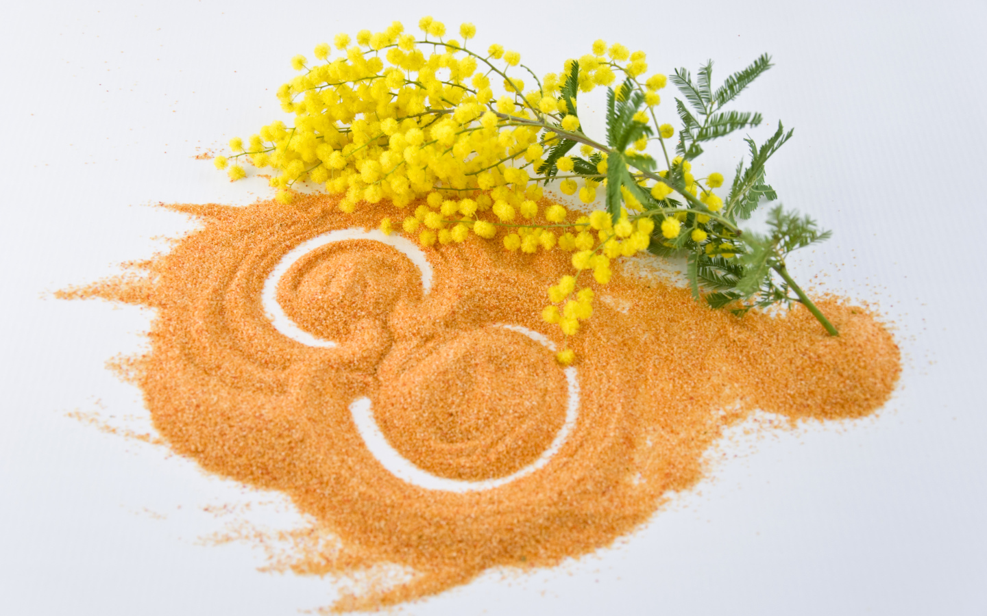 Цифра 8 на песке с веткой мимозы на Международный женский день 8 марта