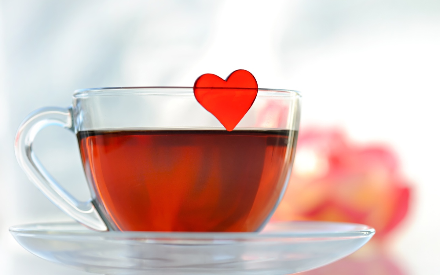 Маленькое красное сердечко в стеклянной чашке с чаем