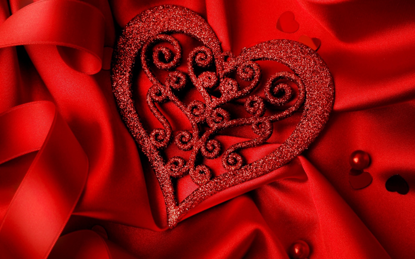 Блестящее сердце на красной атласной ткани 