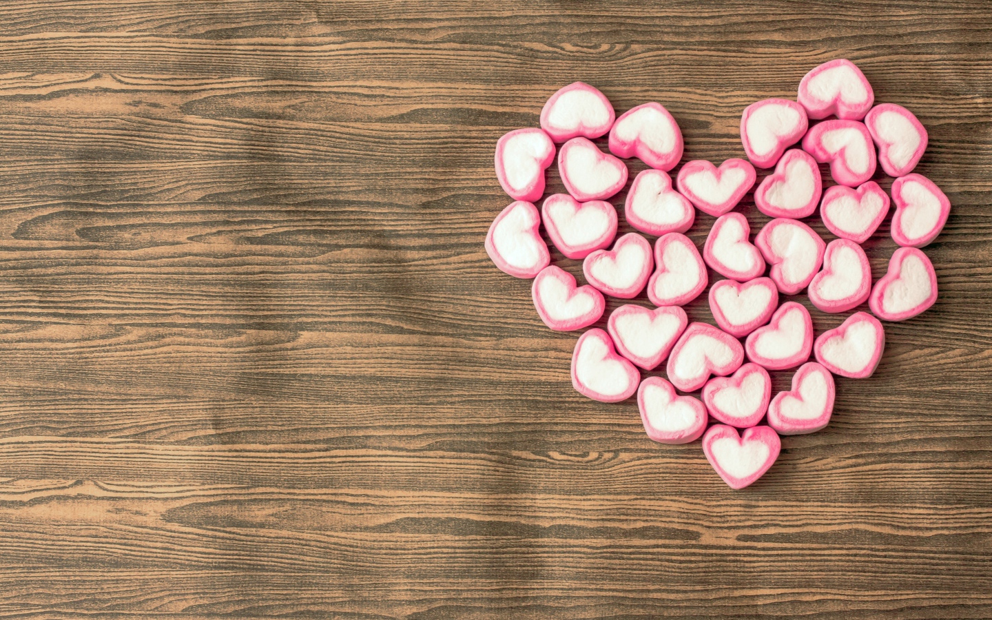 Сердце из конфет в форме сердца на деревянном столе