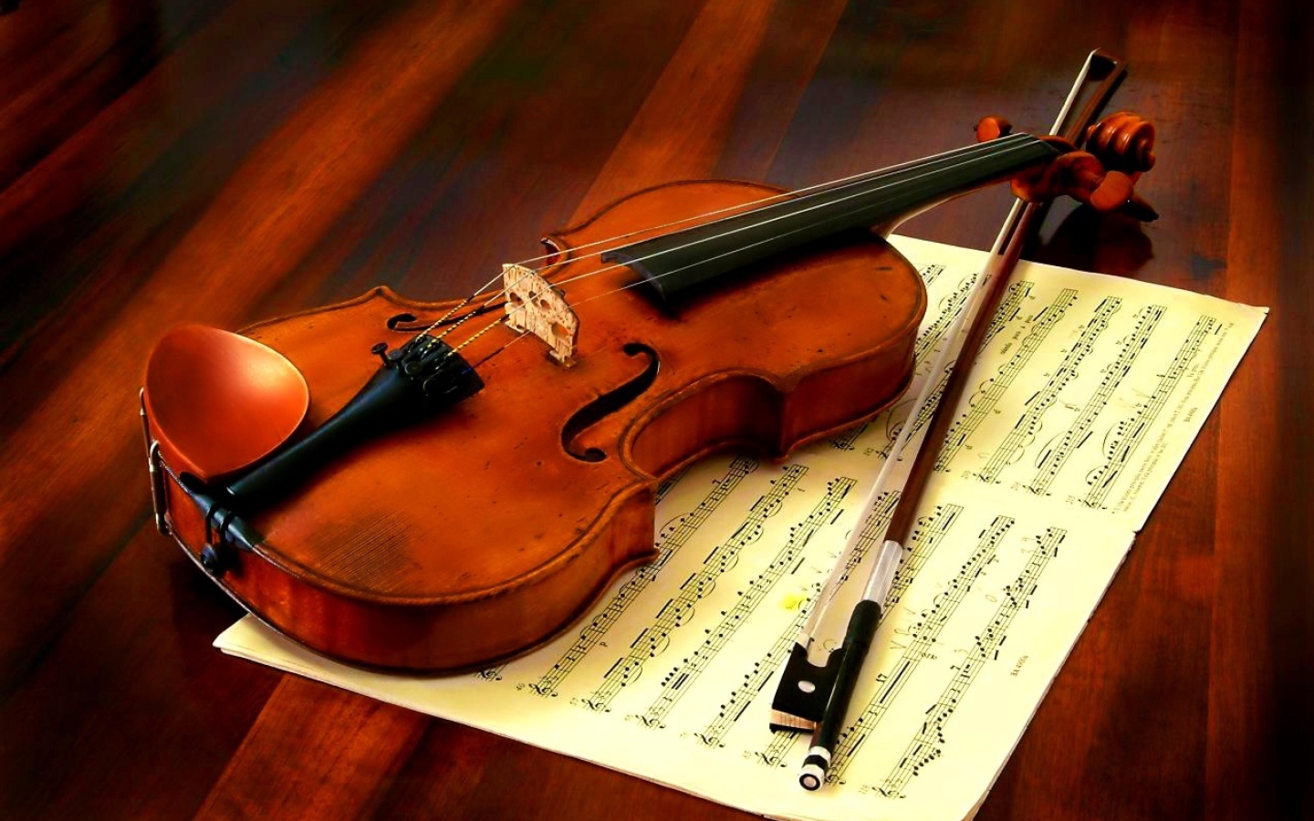 Скрипка со смычком лежат на нотной тетради