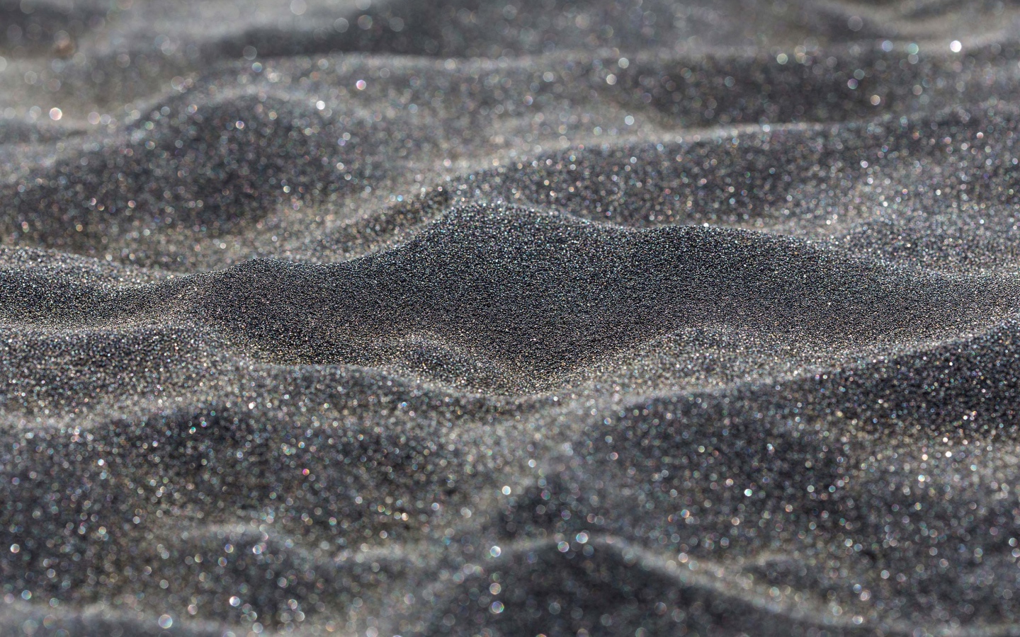 Блестящий черный песок крупным планом