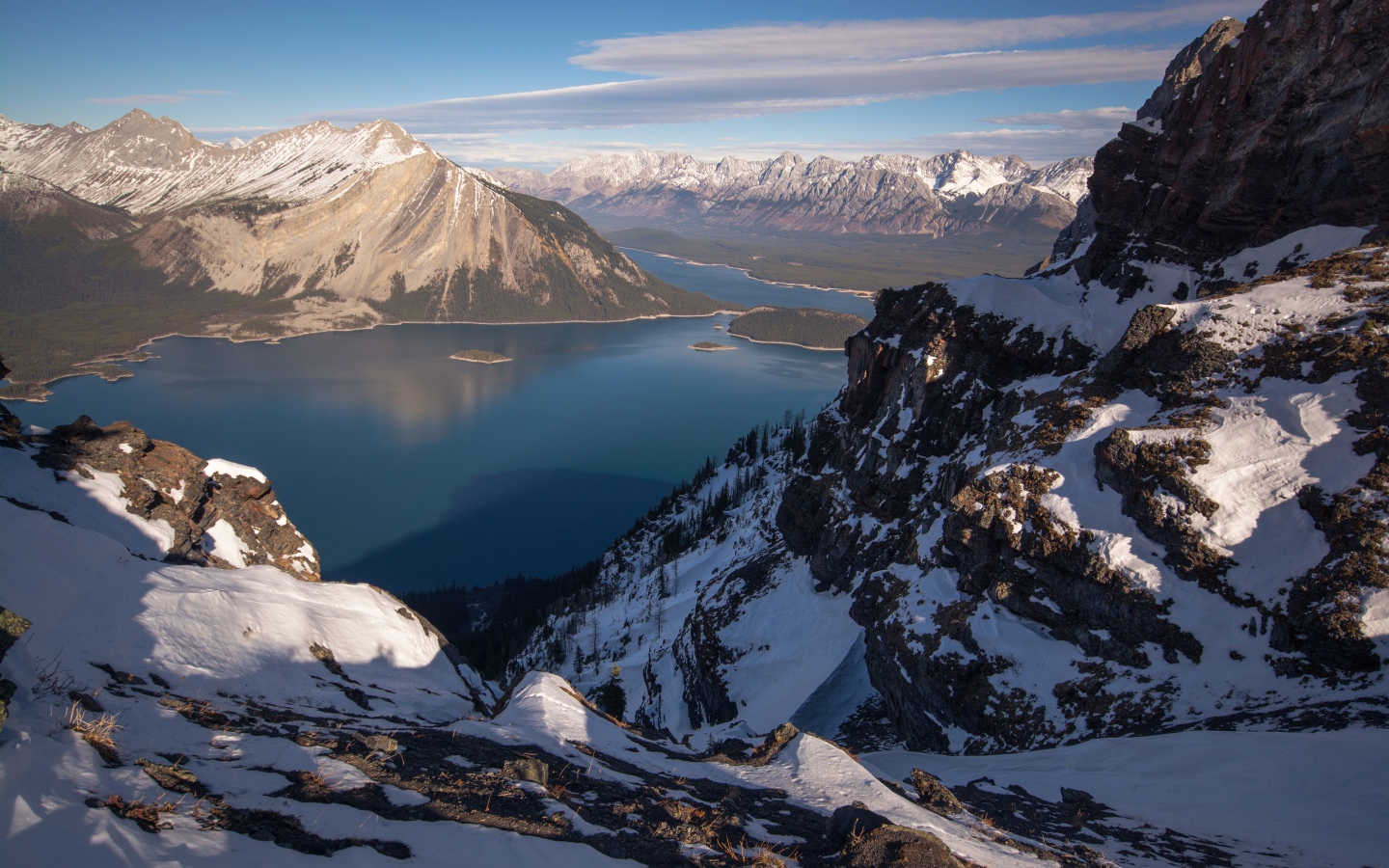 Озеро между заснеженных гор на фоне голубого неба